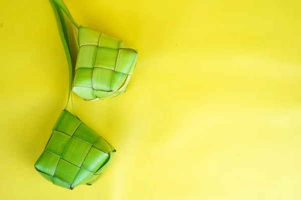 印度尼西亚为庆祝开斋节 人们用Ketupat或编织的棕榈叶做米糕 在黄色背景下隔离 — 图库照片