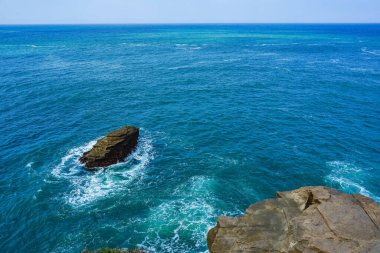 Etrafı dalgalarla çevrili okyanusta kayalar. Pacitan, Doğu Java, Endonezya. Doğa ve manzara fotoğrafçılığı. Boşluğu kopyala.