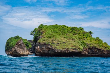Okyanusta, Tanjung Kasap veya Kasap Burnu, Pacitan, Endonezya yakınlarında kaya oluşumu. Hareket halindeki bir tekneden alınmış. Seyahat Fotoğrafçılığı.