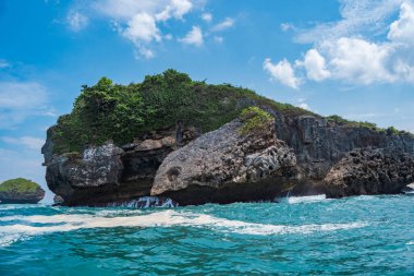 Okyanusta, Tanjung Kasap veya Kasap Burnu, Pacitan, Endonezya yakınlarında kaya oluşumu. Hareket halindeki bir tekneden alınmış. Seyahat Fotoğrafçılığı.
