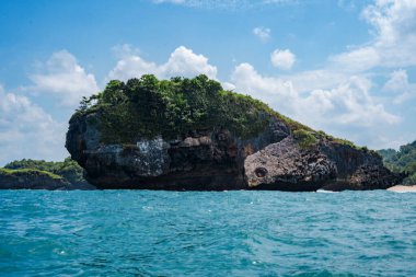 Okyanusta, Tanjung Kasap veya Kasap Burnu, Pacitan, Endonezya yakınlarında kaya oluşumu. Hareket halindeki bir tekneden alınmış. Seyahat Fotoğrafçılığı.