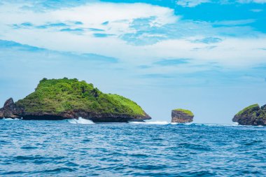 Okyanusta, Tanjung Kasap veya Kasap Burnu, Pacitan, Endonezya yakınlarında kaya oluşumu. Hareket halindeki bir tekneden alınmış. Seyahat Fotoğrafçılığı.