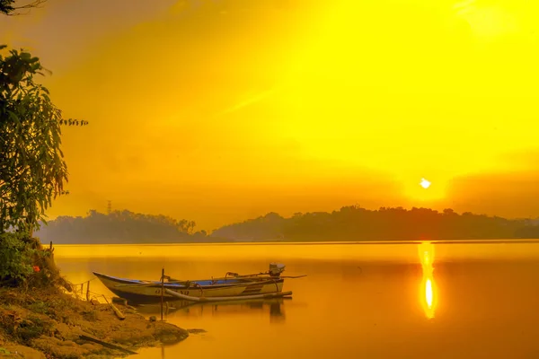 stock image Traditional boat moored on the calm and tranquil lake during sunrise in Jatibarang Dam, Semarang, Indonesia. Long exposure photography.