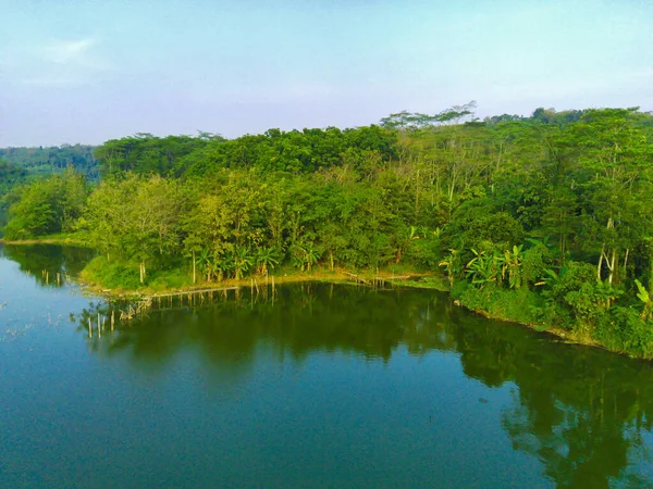 在印度尼西亚Semarang的Lembah Jaibarang 一个有着茂盛绿树 植物和房屋的波涛汹涌的湖中的航拍镜头 无人机摄影 — 图库照片