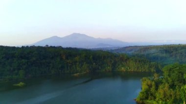Jatibarang, Semarang, Endonezya 'daki ormanlarla çevrili bir gölün büyüleyici hava manzarası. İnsansız hava aracı görüntüleri
