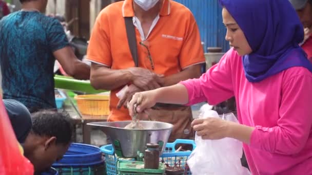 インドネシアのスラバヤの伝統的な市場で新鮮なエビを購入する顧客にサービスを提供する女性 ストリートビデオ — ストック動画