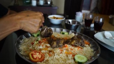 Yemek için Nasi Mandhi 'yi seçen yakın çekim elleri bu lezzetli yemeği seçme ve zevk alma samimi eylemini sergiliyor..