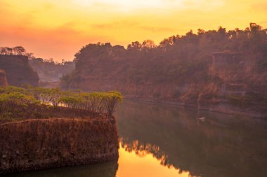 Ranu Manduro, Mojokerto, Endonezya 'da ağaçlarla birlikte gölün üzerinde gün doğumu. Doğa ve manzara fotoğrafçılığı.