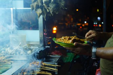 Sate Padang sahnesi, bir çeşit Endonezyalı şiş ve ızgara et yemeği, bir sokak yemekhanesinde açık ateşte pişiriliyor..