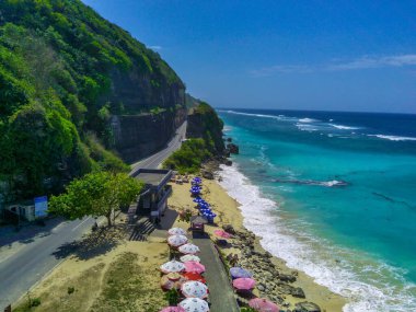 Bali 'deki Pandawa Sahili' nin havadan görünüşü, beyaz kumlu kıyıları, çarpıcı kireçtaşı kayalıkları ve parlak mavi gökyüzü ile nefes kesici. İnsansız hava aracı ile hava görüntüleri.