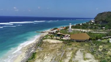 Bali 'deki Pandawa Sahili dalgaların yumuşak sesi ve açık mavi gökyüzü ile güzel mavi bir denize sahiptir. Uzakta Pandawa deniz fenerini de görebilirsiniz. Video bir İHA kullanılarak çekildi..