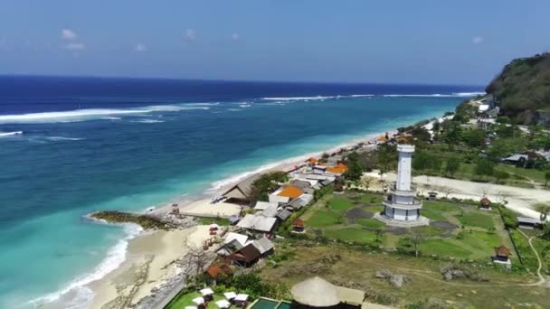 バリ島のパンダワビーチは 波の穏やかな音と澄んだ青空を備えた美しい青い海を特徴としています 遠くからはパンダワ灯台も見ることができます ビデオは無人機を使って撮影された — ストック動画