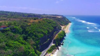 Havadan bakıldığında, Bali 'deki Pandawa Sahili kristal berrak mavi sular, beyaz kumlar, kıyı kayaları ve yol kenarındaki kayalıklarda yetişen yemyeşil bitki örtüsüyle övünüyor. İHA ile çekilen hava görüntüleri.