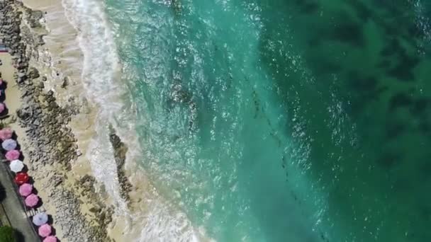 从空中看去 蓝绿色水晶清澈的海浪轻柔地拍击着柔软的白色沙滩海岸 爱抚着岩石的海岸线 用无人驾驶飞机拍摄的空中录像 — 图库视频影像