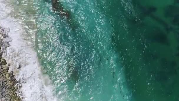从空中看去 蓝绿色水晶清澈的海浪轻柔地拍击着柔软的白色沙滩海岸 爱抚着岩石的海岸线 用无人驾驶飞机拍摄的空中录像 — 图库视频影像
