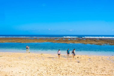 1 Eylül 2023. Bali, Endonezya. Akşamları Bali 'deki Melasti Plajı' ndaki beyaz kumları, mavi denizi ve mavi gökyüzüyle insanların faaliyetleri. Doğa ve İnsan Fotoğrafçılığı.