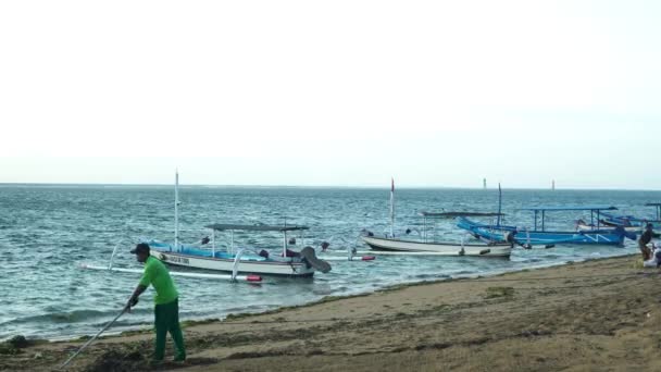 八月三十一日2023年 印度尼西亚 巴厘岛Sanur海滩平静的早晨 氛围生机勃勃 人们都在海滩上活动 看到锚泊的船 波浪轻轻摇曳 轻风轻拂 — 图库视频影像
