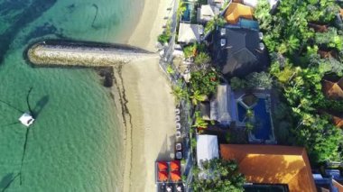 Krem rengi kumu, kristal berrak deniz suyu, yemyeşil ağaçları ve sahil kenarındaki tatil beldeleriyle Cemara Sahili boyunca uç. Hava görüntüleri.