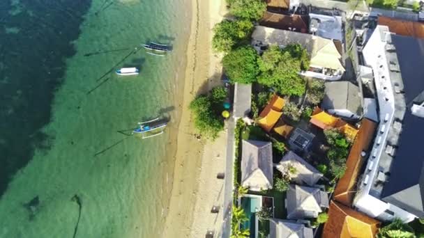 クリーミーな色の砂 クリスタルクリア海水 緑の木 ビーチフロントリゾートの列と一緒にセサラビーチに沿って飛んでください エアリアル映像 — ストック動画