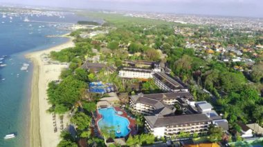 Krem rengi kumu, kristal berrak deniz suyu, yemyeşil ağaçları ve sahil kenarındaki tatil beldeleriyle Cemara Sahili boyunca uç. Hava görüntüleri.