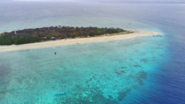 Pulau Tabuhan, Banyuwangi 'nin üzerinde süzülür ve beyaz kumlu sahillerine ve berrak sularına hayret eder. Bu hava görüntüsü bu adanın güzelliğini eşsiz bir perspektiften yakalıyor. Hava Görüntüsü.