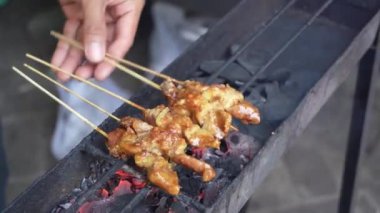 Satay ustasının eli iş başında, Endonezya, Surabaya 'da açık kömür ateşinin üzerinde et şişleri pişiriyor..