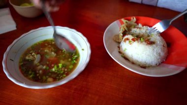 İki el Soto Otot ya da tendon çorbasını karıştırır, geleneksel bir Java çorbası biftek bacakları ve mis kokulu bir et suyu..