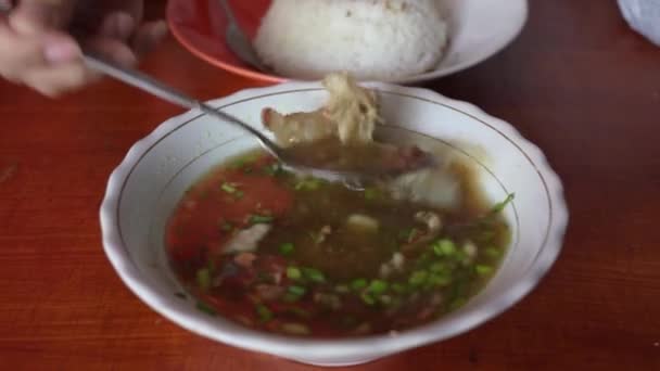 两只手搅拌着一碗蒸着的Soto Otot或Tendon汤 这是一种用牛肉片和香喷喷而成的爪哇传统汤 — 图库视频影像
