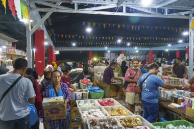 24 Kasım 2023. Surabaya, Endonezya. Pasar Kue Subuh ya da pazar yerinde şafak vakti abur cubur satılıyor. Kalabalık bir pazar yerinde insanlar renkli tezgahların etrafında toplanmış çeşitli abur cuburlarla dolup taşıyor. Sokak Editörü Fotoğrafçılık.
