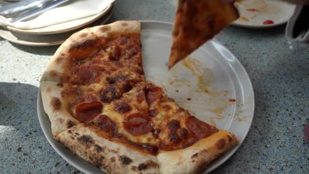 테이블에있는 접시와 포크와 나이프를 사용하여 하나에서 슬라이스 피자를 선택하는 — 비디오