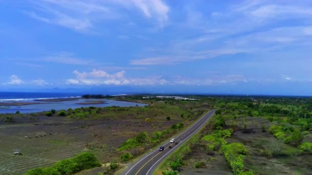 一辆汽车沿着蜿蜒曲折的沿海公路 在Jls或印度尼西亚的南部海岸线公路上 被浩瀚的蓝色海洋吓得胆战心惊 — 图库视频影像
