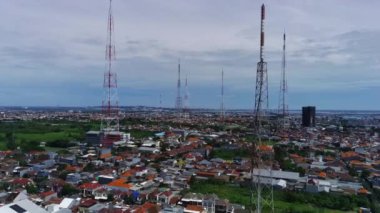 Endonezya, Batı Surabaya 'nın üzerinde süzülen bu drone görüntüsü kampung yaşamının canlı dokusunu yakalıyor. Güneş ışığı teneke çatılarda parlıyor, aşağıdaki dar sokaklar üzerinde karmaşık desenler oluşturuyor..