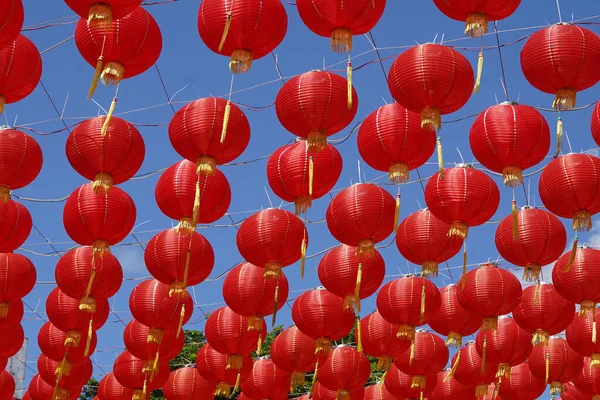 A collection of red paper lanterns hanging against a clear blue sky welcoming Chinese New Year in Solo, Central Java, Indonesia.