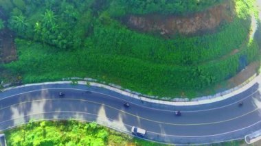 Prigi Beach, Trenggalek, Doğu Java yakınlarındaki yemyeşil Endonezya ormanının üzerinde bu çarpıcı insansız hava aracı videosuyla süzülüyor. Yükselen ağaçlardan canlı yapraklara kadar doğal manzaranın güzelliğini yakalayın. Doğa aşıkları ve seyahat meraklıları için mükemmel..