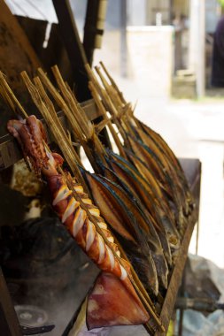 Skewers of squid and fish cooked over an open fire, a delicious and affordable meal enjoyed by locals and tourists alike in Trenggalek, East Java, Indonesia. clipart