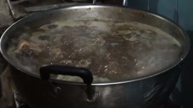 Sobanın üstünde sığır kuyruğu ve sakatat çorbası için haşlanmış et güveci dolu büyük bir tencere. Surabaya, Endonezya 'da.