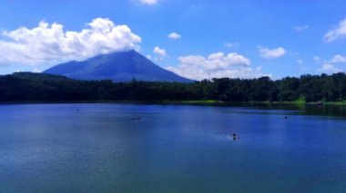 Ranu Klakah gölü, arkasında görkemli bir dağ olan Lumajang gölü. Doğu Java, Endonezya 'daki dağın eteklerinde yemyeşil bir alan bulunur..