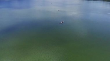 Merkezinde geleneksel bir balıkçı olan küçük, yeşil bir gölün havadan çekilmiş görüntüleri. Ranu Klakah, Lumajang, Doğu Java, Endonezya 'da göl kıyısında yemyeşil ağaçlar var..