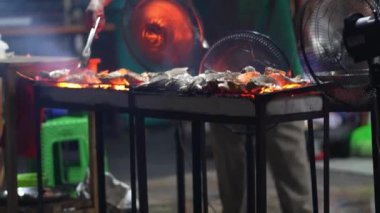 Jakarta Gıda Satıcısı 'nda ızgara istiridye. Izgarada cızırdayan, dolgun istiridyeler her ısırıkta denizin tadını sunuyor..