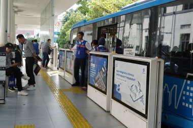 April 11, 2024. Jakarta, Indonesia. The atmosphere at Trans Jakarta Bus shelter. Expect festive vibes with higher passenger volume at the shelters the day after Eid al Fitr clipart