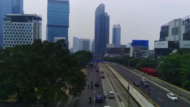 印度尼西亚雅加达Jalan Jenderal Sudirman城市景观的空中景观 繁忙的街道上排着高大的摩天大楼 汽车和人在下面移动 空中录像 — 图库视频影像