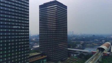 Jakarta, Endonezya 'daki Jalan Jenderal Sudirman' ın şehir manzarası. Uzun gökdelenler işlek caddede, arabalar ve insanlar aşağıda hareket ediyor. Hava görüntüleri