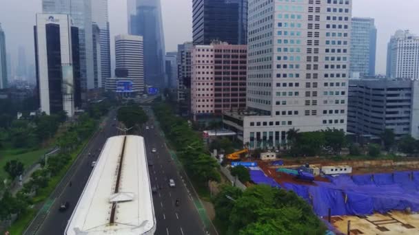 印度尼西亚雅加达Jalan Jenderal Sudirman城市景观的空中景观 繁忙的街道上排着高大的摩天大楼 汽车和人在下面移动 空中录像 — 图库视频影像