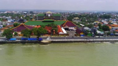 Doğu Java 'daki Tuban kıyı şeridi boyunca bir şehir. Sahilde evler ve okyanusta sallanan tekneler var..