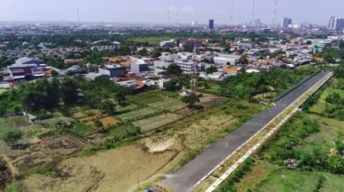 Surabaya, Endonezya 'da inşaat halindeki bir binanın havadan görüntüsü. Görünürde yol çalışması ve yerleşim alanı da var..