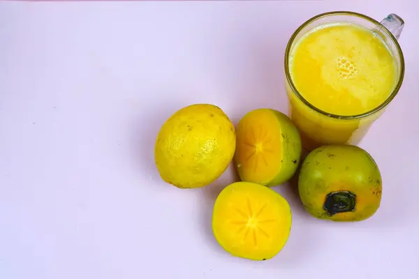 stock image a glass of persimmon lemonade. Persimmon lemonade is a refreshing drink made with persimmon juice, lemon juice, water, and sugar. It is a great way to cool down on a hot day and is also a good source of vitamin C.