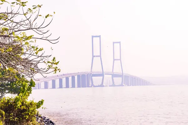 stock image The Suramadu Bridge, the longest bridge in Indonesia, stretches across the Madura Strait during a foggy day