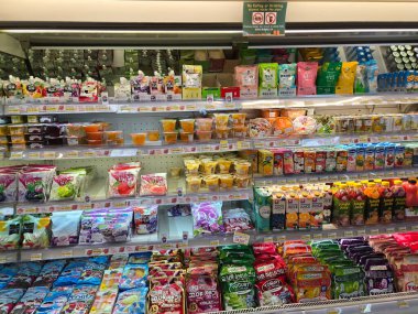 17 Ağustos 2024, Jakarta, Endonezya. Bir markette dondurulmuş bir bölümde çeşitli içecekler, atıştırmalıklar ve yoğurt ürünleri depolanmış. Meyve suları, yoğurt, jöle ve diğer atıştırmalıklar sergileniyor..