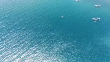 Lombok, Endonezya 'daki Cemare Sahili' nin nefes kesici hava manzarası, bereketli bir hindistan cevizi plantasyonu, sakin bir koy ve dramatik bir gökyüzü altında görkemli dağlar..