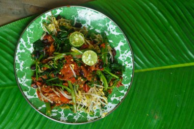 A vibrant plate of Plecing Kangkung, Lombok, Indonesian traditional food. Featuring stir fried water spinach topped with a spicy sambal made from chili peppers, tomatoes, shallots, and garlic, garnished with bean sprouts and lime wedges. clipart